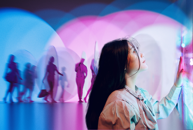 woman touching screen with lights and shadows behind her