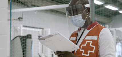 person wearing mask looking at paperwork
