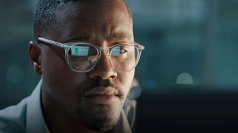 man in glasses looking at laptop