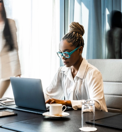 woman with blue glasses working at laptop