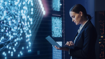 woman working on laptop in front of digital screen