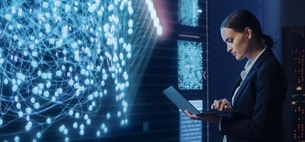 woman holding laptop in front of digital screen