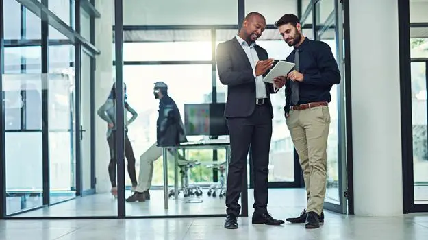 two male colleagues reviewing tablet