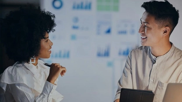 male and female colleague happily discussing 