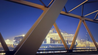 Yellow steel bridge and container terminal at dawn