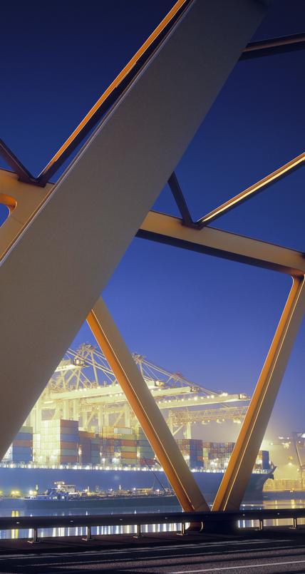 Yellow steel bridge and container terminal at dawn