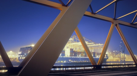 Yellow steel bridge and container terminal at dawn