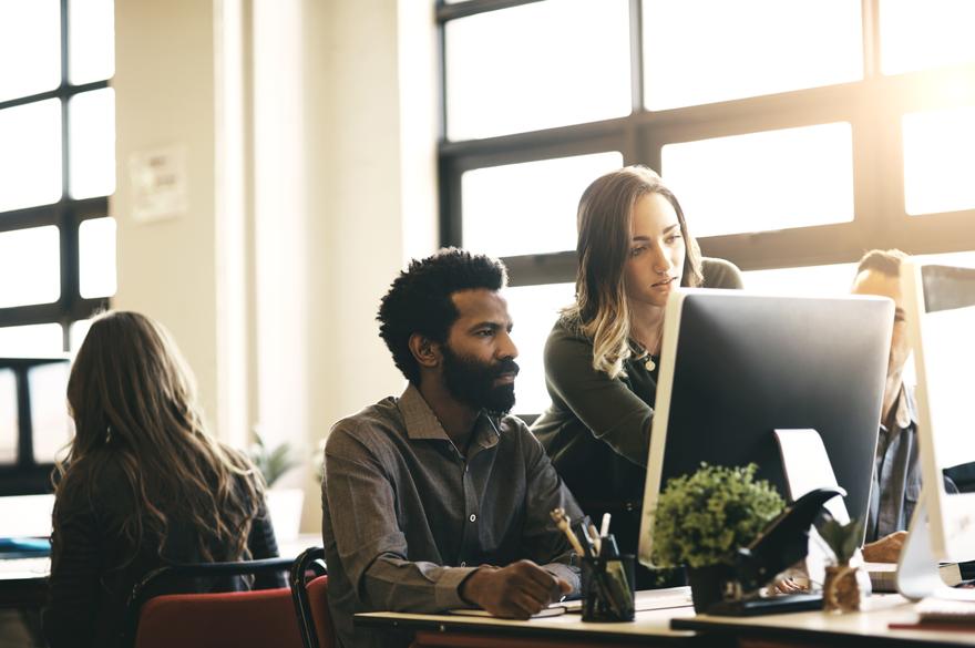 male and female colleague looking at desktop screen together