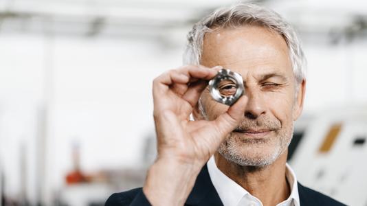 Manager in high tech enterprise, checking machine parts