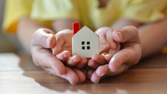 Man is holding small house 