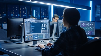 Smart Female IT Programer Working on Desktop Computer in Data Center System Control Room