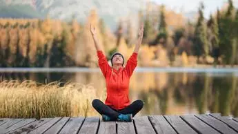 A senior woman sitting and and meditating.