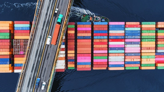 A container ship passes beneath a suspension bridge as it departs for Europe