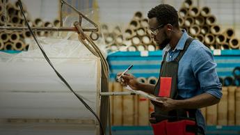 man holding pen and paper in warehouse