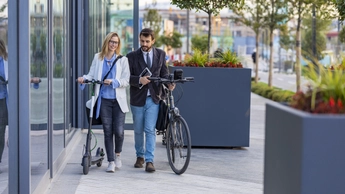 man and woman walking bikes together
