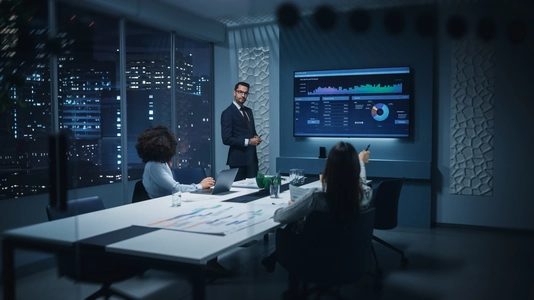 business colleagues discussing screen in meeting room