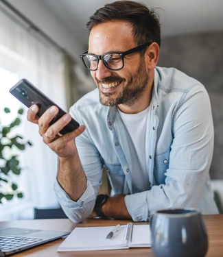 Man smile and enjoy while use smart phone at home