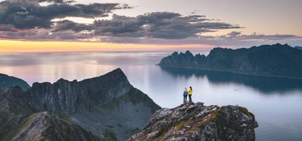 two friends admiring the sunset from top of a high