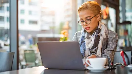 Woman is using laptop in coffee bar