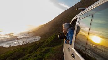 person with head out of car window admiring the view