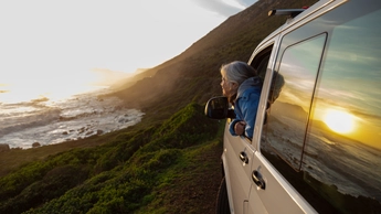 person with head out of car window admiring the view