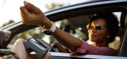 Selective focus shot of woman using smart watch to pay for drive through order