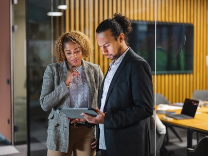 two people conversing over tablet