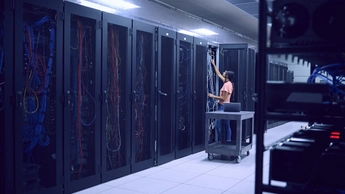 Female technician working in server room
