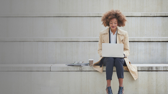 young businesswoman using laptop on steps