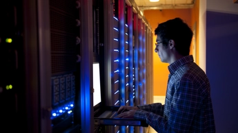 Man is using laptop in data warehouse