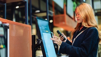 woman working at screen with mobile device