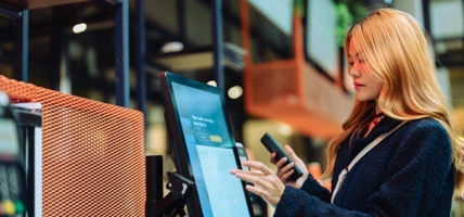 woman working at screen with mobile device