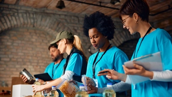 Multiracial group of volunteers packing donated food