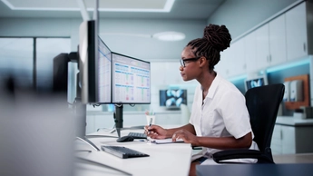 Hospital Doctor Using Spreadsheet For Billing Codes On Desktop
