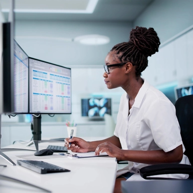 Hospital Doctor Using Spreadsheet For Billing Codes On Desktop