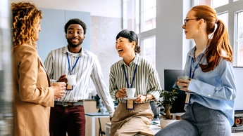 Coworkers talking and drinking coffee at office