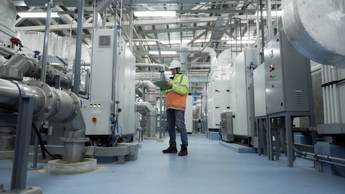Asian Engineer Performing Pipe System Inspection in Modern Industrial Facility