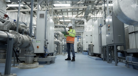 Asian Engineer Performing Pipe System Inspection in Modern Industrial Facility