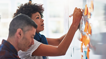 woman adding sticky notes to board