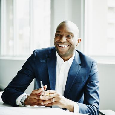 business man happily smiling while sitting at table