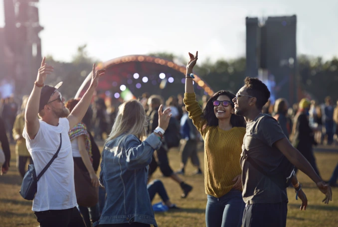 Friends dancing at festival with arms in air