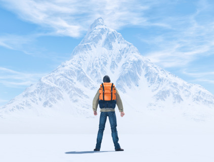 Hiker in yellow jacket with snowy mountain background