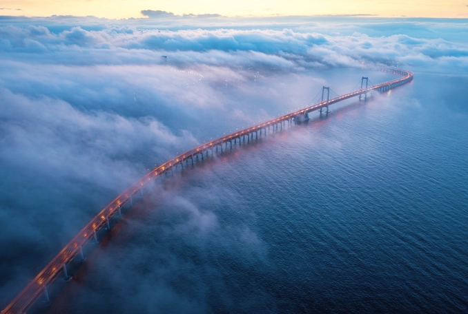 long bridge covered in clouds