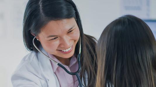 Female doctor wearing stethoscope checking patient