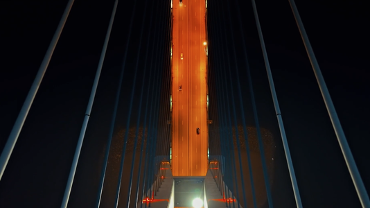 view looking down on bridge as cars cross at night
