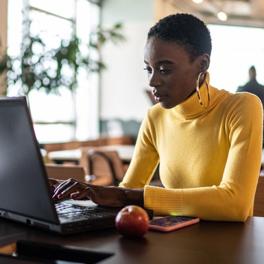 woman working at laptop with apple