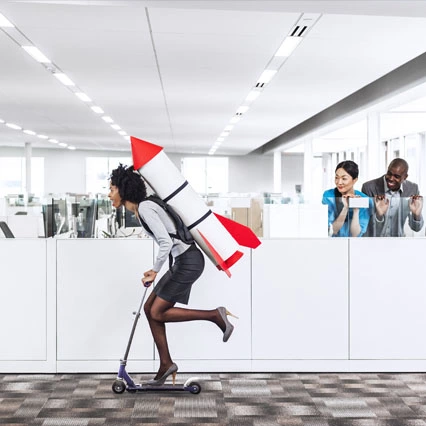 woman riding scooter with rocket on her back