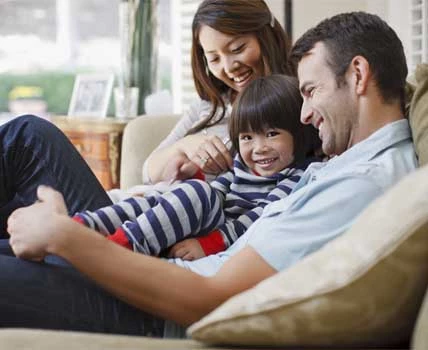 family sitting on a sofa together smiling