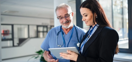 doctor and hospital employee reviewing tablet