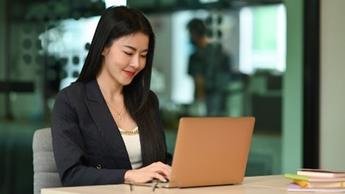 woman happily working at laptop